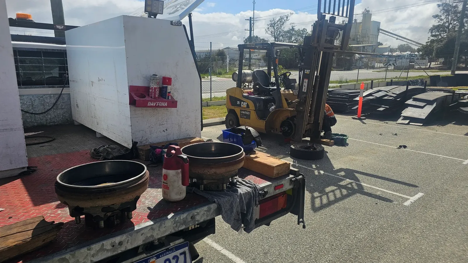 Forklift servicing, a CAT forklift up on blocks with a wheel off